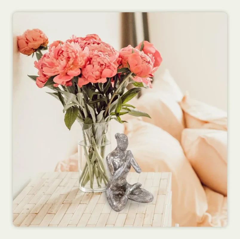 A statue placed next to a flower vase A statue placed next to a flower vase
